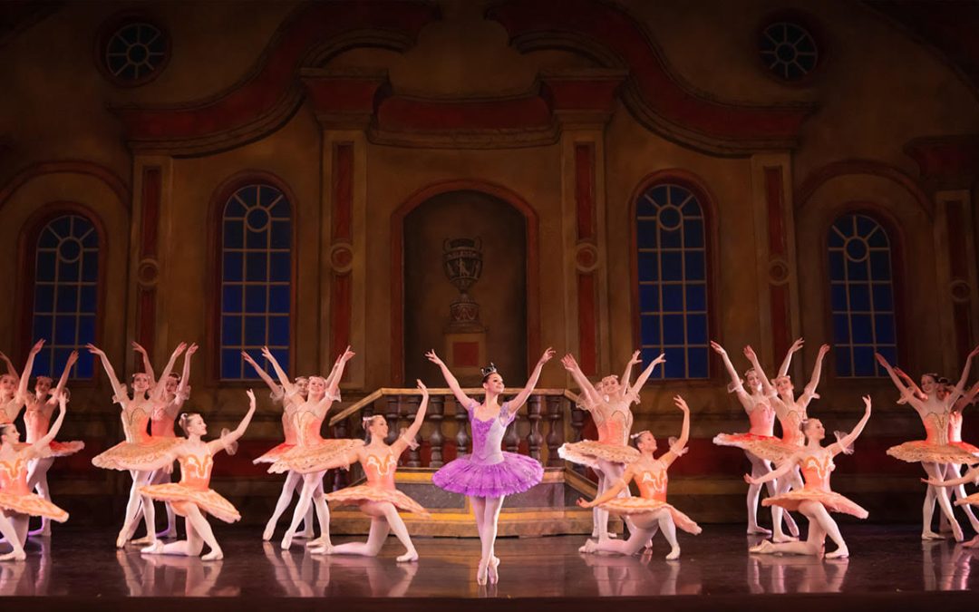 Ballet company performing on stage after summer ballet training program